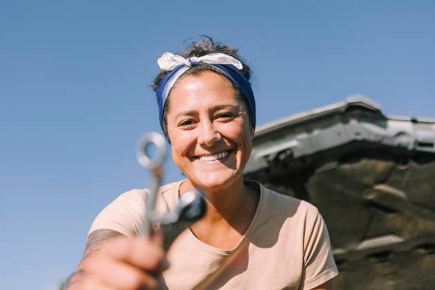 PR_ID31484_11751_MarielaTattos.jpg, MR_ID31484_22720_MarielaWaczinsky.jpg A cheerful woman stands next to her broken down car on a sunny day in Australia. She holds tools, ready to tackle the vehicle issues, embracing the challenge with a smile., Property released Model Released JuanAizpuru_ID31484_1070459_022 Copyright: xJuanxAizpurux