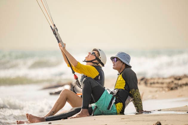MR_ID31343_22933_DarioImitola.jpg, MR_ID31343_22932_SoniaFenoglio.jpg Student and instructor sit on the sandy shore of Salinas del Rey, Atlantico, Colombia, during a kitesurf lesson. The instructor guides the student as they prepare to catch the waves. Model Released VictorCuenca_ID31343_1065775_004 Copyright: xVictorxCuencax
