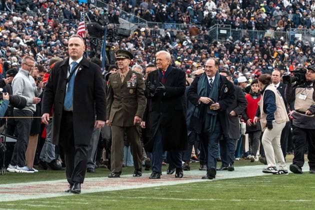 December 13, 2025, Baltimore, Maryland, USA: President DONALD TRUMP claps as he walks down the sideline with United States Naval Academy Superintendent Marine Corps Lieutenant General MICHAEL J. BORGSCHULTE and Secretary of the Navy JOHN PHELAN. Baltimore USA - ZUMAs365 20251213_znp_s365_004 Copyright: xJoeyxSussmanx