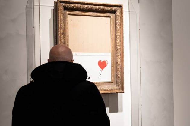 Sotheby s Icons and Bing Crosby Exhibitions press preview A visitor examines BANKSY Girl Without Balloon sold for more than 1 million dollars on view during press preview at Sotheby s Icons and Bing Crosby Exhibitions in New York, NY on December 13, 2025. New York New York United States Copyright: LevxRadin