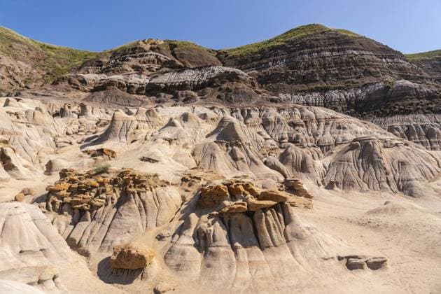 Atemberaubender Panoramablick auf das trockene Drumheller Tal mit einzigartigen Hoodoo Formationen unter klarem blauem Himmel, der die geologischen Wunder der kanadischen Badlands hervorhebt Breathtaking panoramic view of the arid drumheller valley showcasing unique hoodoo formations under a clear blue sky, highlighting the geological wonders of the canadian badlands Copyright: imageBROKER UnaixHuizi ibxuhu15874437.jpg