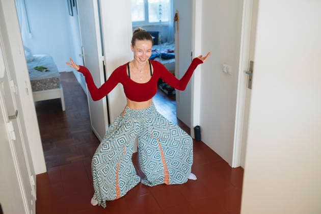 Ausdrucksstarke Frau zeigt spielerisches Selbstvertrauen während einer Indoor-Aktivitätssession caucasian woman crouching in hallway with open arms and broad smile, expressive low stance conveying playful confidence (License=RF) ,model released, Symbolfoto Copyright: xZoonar.com OleksiixHrecheniukx 24350228 ,model released, Symbolfoto ,property released