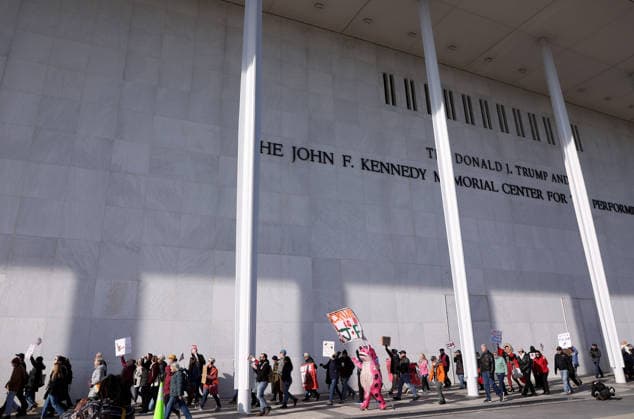 December 20, 2025, Washington Dc, Virginia, USA: Demonstrators hold signs as they march during a protest in front of the John F. Kennedy Memorial Center for the Performing Arts building, in Washington, D.C., USA, on December 20, 2025. Activists opposed adding the name Donald J. Trump to the Kennedy Center for the Performing Arts. Washington Dc USA - ZUMAs337 20251220_znp_s337_019 Copyright: xGentxShkullakux
