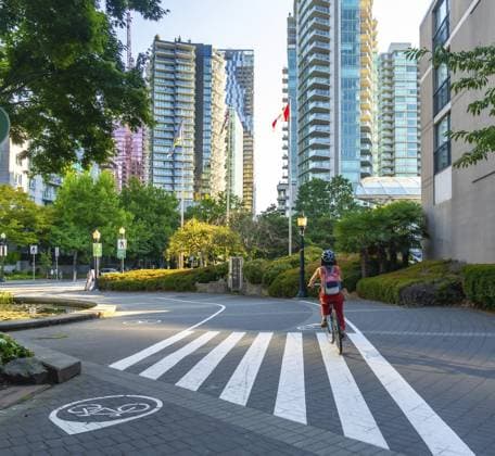 Kanadische Flagge weht zwischen modernen Gebäuden, während eine Frau mit Rucksack und Helm in der Innenstadt von Vancouver, Britisch Kolumbien, Fahrrad fährt Canadian flag waving between modern buildings while a woman with backpack and helmet rides her bicycle in vancouver downtown, british columbia Copyright: imageBROKER UnaixHuizi ibxuhu15971120.jpg ,model released, Symbolfoto ,property released