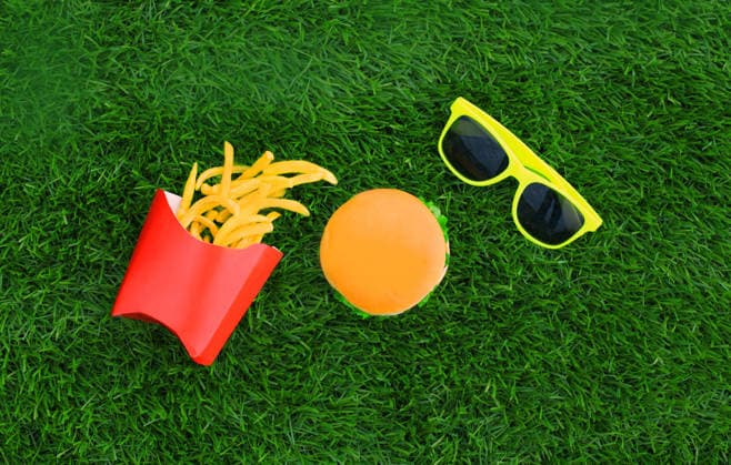 Fast food concept - burger, french fries and sunglasses on the grass background Fast food concept - burger, french fries and sunglasses on the grass background, 62171698.jpg RECORD DATE NOT STATED
