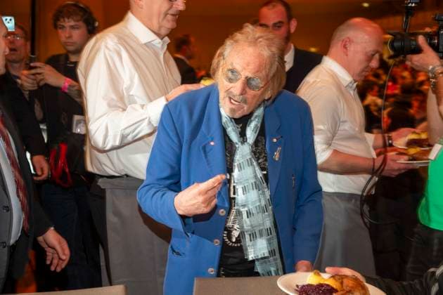 abb Frank Zander as celebrity waiter serving plates with Gaensekeuele red cabbage and dumplings at the 31 Frank Zander Christmas Party Christmas Dinner for Homeless and Needy People 2025 at Estrel Convention Center on December 22, 2025 in Berlin Berlin Germany