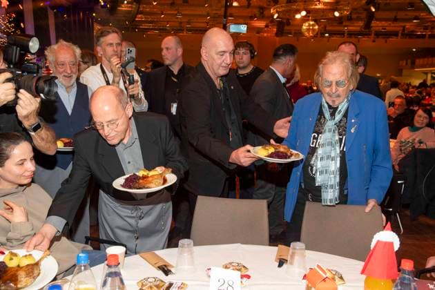 abb Gregor Gysi and Frank Zander as celebrity waiters serving plates with Gaensekeuele red cabbage and dumplings at the 31 Frank Zander Christmas party Christmas dinner for homeless and needy people 2025 at Estrel Convention Center on December 22, 2025 in Berlin Berlin Germany