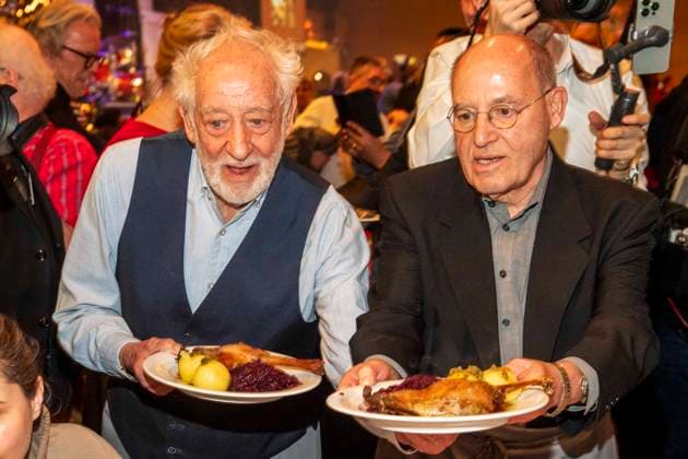 abb Dieter Hallervorden and Gregor Gysi as celebrity waiters serving plates with Gaensekeuele red cabbage and dumplings at the 31 Frank Zander Christmas Party Christmas Dinner for Homeless and Needy People 2025 at Estrel Convention Center on December 22, 2025 in Berlin Berlin Germany