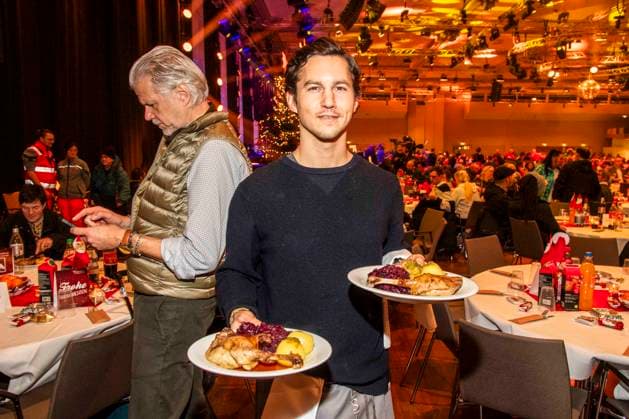 abb Tim Oliver Schultz as celebrity waiter serving plates with Gaensekeuele red cabbage and dumplings at the 31 Frank Zander Christmas Party Christmas Dinner for Homeless and Needy People 2025 at Estrel Convention Center on December 22, 2025 in Berlin Berlin Germany