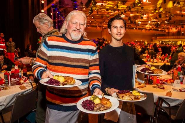 abb Frank Kessler and Tim Oliver Schultz as celebrity waiters serving plates with Gaensekeuele red cabbage and dumplings at the 31 Frank Zander Christmas Party Christmas Dinner for Homeless and Needy People 2025 at Estrel Convention Center on December 22, 2025 in Berlin Berlin Germany