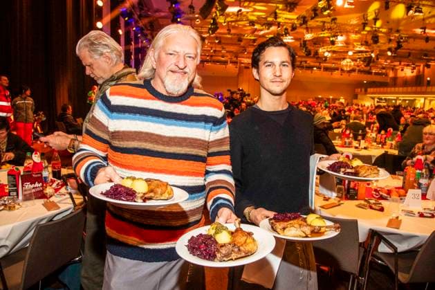 abb Frank Kessler and Tim Oliver Schultz as celebrity waiters serving plates with Gaensekeuele red cabbage and dumplings at the 31 Frank Zander Christmas Party Christmas Dinner for Homeless and Needy People 2025 at Estrel Convention Center on December 22, 2025 in Berlin Berlin Germany