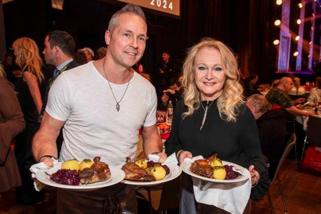 abb Mitch Keller and Nicole as celebrity waiters serving plates with Gaensekeuele red cabbage and dumplings at the 31 Frank Zander Christmas Party Christmas Dinner for Homeless and Needy People 2025 at Estrel Convention Center on December 22, 2025 in Berlin Berlin Germany