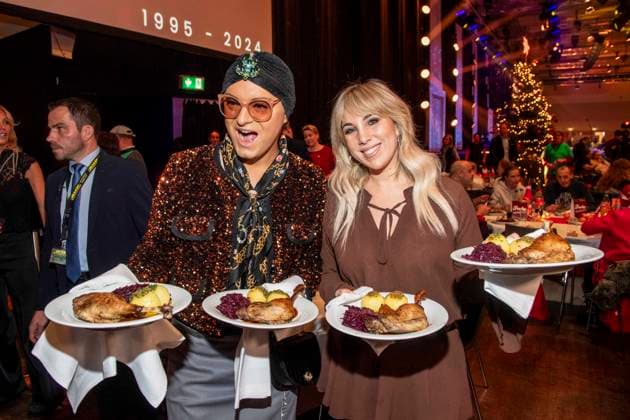 abb Julian F M Stoeckel and Annemarie Eilfeld as celebrity waiters serving plates with Gaensekeuele red cabbage and dumplings at the 31 Frank Zander Christmas Party Christmas Dinner for Homeless and Needy People 2025 at Estrel Convention Center on December 22, 2025 in Berlin Berlin Germany