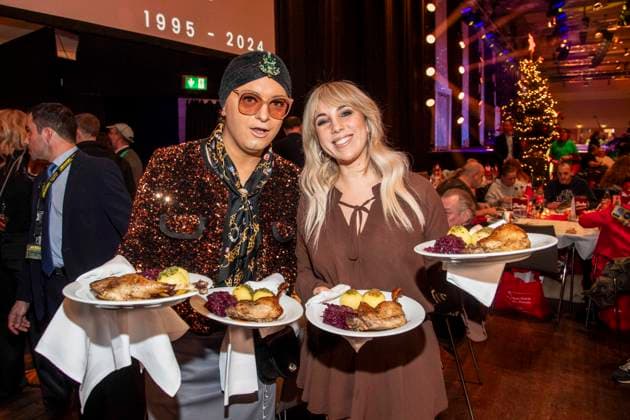 abb Julian F M Stoeckel and Annemarie Eilfeld as celebrity waiters serving plates with Gaensekeuele red cabbage and dumplings at the 31 Frank Zander Christmas Party Christmas Dinner for Homeless and Needy People 2025 at Estrel Convention Center on December 22, 2025 in Berlin Berlin Germany