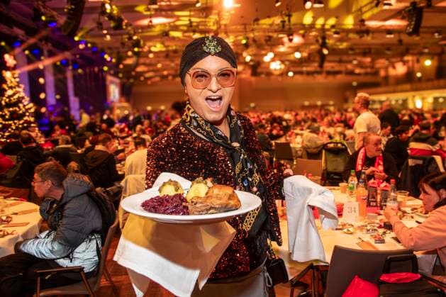 abb Julian F M Stoeckel as celebrity waiter serving plates with Gaensekeuele red cabbage and dumplings at the 31 Frank Zander Christmas Party Christmas Dinner for Homeless and Needy People 2025 at Estrel Convention Center on December 22, 2025 in Berlin Berlin Germany