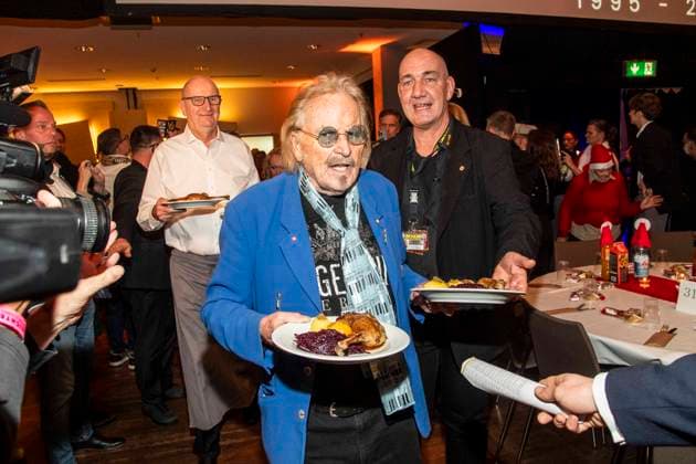 abb Frank Zander as celebrity waiter serving plates with Gaensekeuele red cabbage and dumplings at the 31 Frank Zander Christmas Party Christmas Dinner for Homeless and Needy People 2025 at Estrel Convention Center on December 22, 2025 in Berlin Berlin Germany
