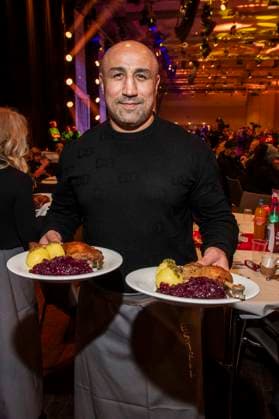 abb Arthur Abraham ex boxer as celebrity waiter serving plates with Gaensekeuele red cabbage and dumplings at the 31 Frank Zander Christmas party Christmas dinner for homeless and needy people 2025 at Estrel Convention Center on December 22, 2025 in Berlin Berlin Germany