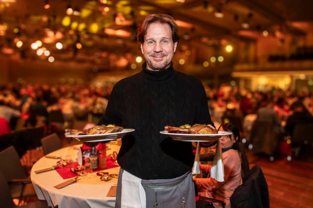 abb: Thomas Heinze Schauspieler als Promi Kellner beim Servieren von Teller mit Gaensekeuele Rotkohl und Kloesse bei der 31. Frank Zander Weihnachtsfeier Weihnachtsessen fuer Obdachlose und Beduerftige Menschen 2025 im Estrel Convention Center am 22.12.2025 in Berlin Berlin Deutschland