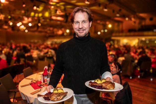 abb: Thomas Heinze Schauspieler als Promi Kellner beim Servieren von Teller mit Gaensekeuele Rotkohl und Kloesse bei der 31. Frank Zander Weihnachtsfeier Weihnachtsessen fuer Obdachlose und Beduerftige Menschen 2025 im Estrel Convention Center am 22.12.2025 in Berlin Berlin Deutschland
