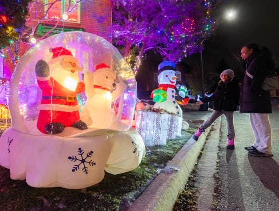 (251223) -- MISSISSAUGA, Dec. 23, 2025 -- People look at Christmas-themed lights and decorations outside a house in Mississauga, Ontario, Canada, Dec. 22, 2025. (Photo by Xinhua) CANADA-MISSISSAUGA-CHRISTMAS DECORATIONS ZouxZheng 