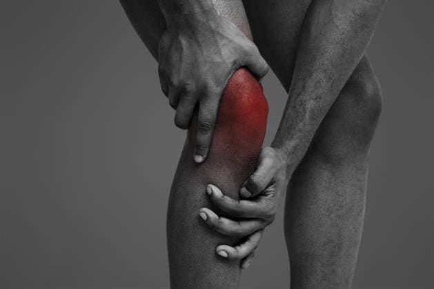 Young man massaging his painful knee, close up Trauma, stretching. Cropped of black man massaging his sore injured knee, white background, model released, , 62283580.jpg RECORD DATE NOT STATED