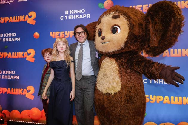 RUSSIA, MOSCOW - DECEMBER 24, 2025: Actors Ilya Kondratenko, Yeva Smirnova and TV host Andrei Malakhov (L-R) pose with an artist dressed as the title character on the red carpet during the premiere of the family comedy Cheburashka 2 by Dmitry Dyachenko at the KARO 11 Oktyabr cinema on Novy Arbat Street (New Arbat Avenue). Valery Sharifulin TASS  86692116