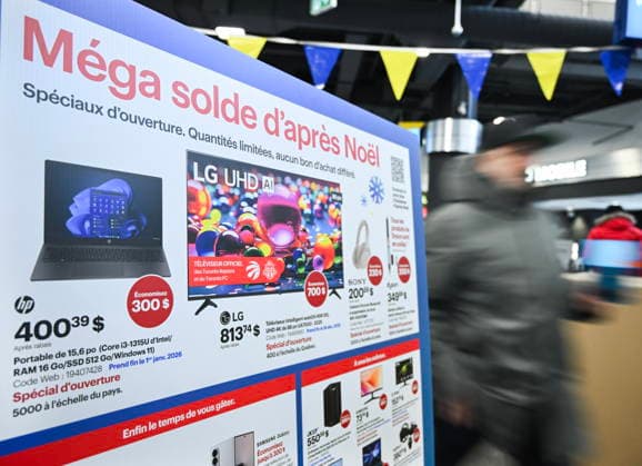 December 26, 2025, Montreal, Pq, Canada: A person walks by a sign advertising big discounts at a Best Buy electronics store on Boxing Day in Montreal, Friday, Dec. 26, 2025. Montreal Canada  - ZUMAc35_ 20251226_zaf_c35_002 Copyright: xGrahamxHughesx