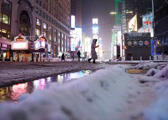 Pedestrians cross Seventh Avenue near Times Square as snow falls in the early morning on Saturday, December 27, 2025 in New York City. A winter storm warning was issued for the entire metro area, from southern Connecticut to northeast New Jersey and southeast New York.  NYP20251227104 JOHNxANGELILLO