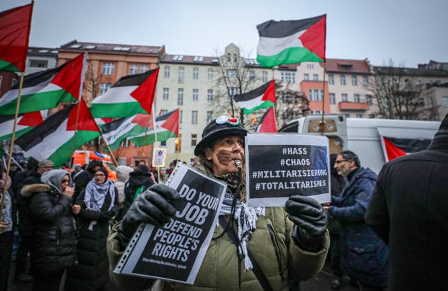 December 27, 2025, Berlin, Berlin, Germany: A demonstrator holds signs during a pro-Palestinian rally in Berlin, Germany, as protesters wave Palestinian flags and march through the city streets in solidarity with Palestine. Berlin Germany - ZUMAa268 20251227_zip_a268_017 Copyright: xAbdelrahmanxAlkahloutx