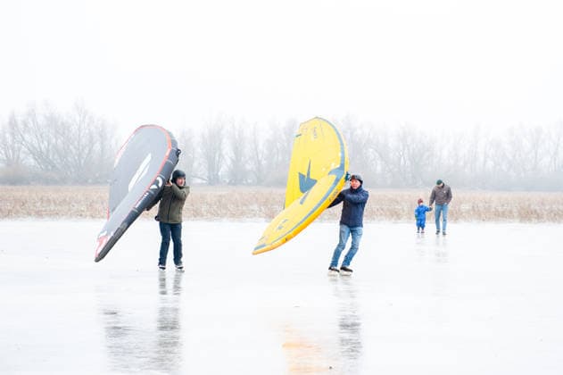 December 27, 2025, Nijmegen, Netherlands: Two men are skating on the ice lake with the help of wings. After several days of sub-zero temperatures during the night, the water of some lakes started to freeze over. People took the chance to skate on one of the frozen lakes close to the Dutch city of Nijmegen. It takes at least four whole days of below-freezing temperatures to form ice that™s safe to walk and skate on, and that only applies to ponds or lakes with no currents. Nijmegen Netherlands - ZUMAs197 20251227_aab_s197_052 Copyright: xAnaxFernandezx