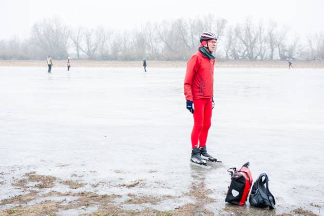 December 27, 2025, Nijmegen, Netherlands: A man in red clothes is taking a break from skating on the ice lake. After several days of sub-zero temperatures during the night, the water of some lakes started to freeze over. People took the chance to skate on one of the frozen lakes close to the Dutch city of Nijmegen. It takes at least four whole days of below-freezing temperatures to form ice that™s safe to walk and skate on, and that only applies to ponds or lakes with no currents. Nijmegen Netherlands - ZUMAs197 20251227_aab_s197_059 Copyright: xAnaxFernandezx