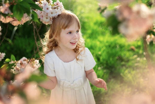 Child girl standing among flowering branches and greenery. Corby, England, United Kingdom CR_JNDO251226-1916975-01 ,model released, Symbolfoto