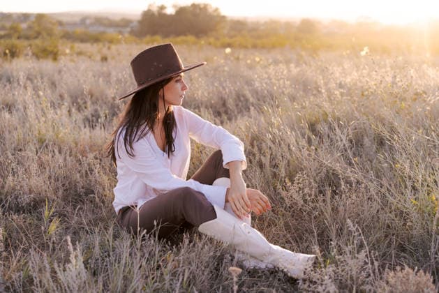 Woman wearing a brown hat and brown pants is sitting in a field Woman wearing a brown hat and brown pants is sitting in a field. She is wearing white pants and a white shirt, model released, , 97797514.jpg RECORD DATE NOT STATED