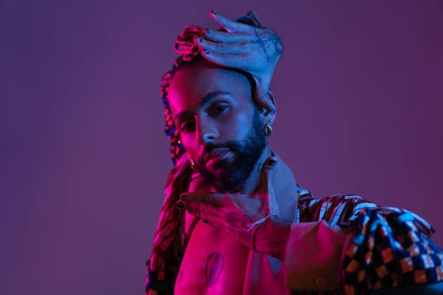 Neon light studio close-up portrait handsome black gay man looking camera. Retro wave or synth wave portrait stylish serious african-american dancer man studio shoot. High Fashion male model dance in colorful bright neon lights posing., model released, , 97874314.jpg RECORD DATE NOT STATED