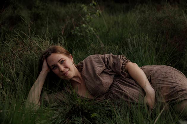 Pregant woman resting in tall grass wearing a brown dress Amsterdam, North Holland, Netherlands CR_RTBZ2512295B-1921297-01 ,model released, Symbolfoto
