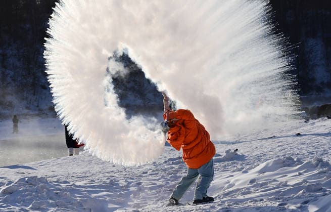 (260101) -- ARXAN, Jan. 1, 2026 -- A tourist plays a water to ice game by splashing water into the cold air by the Halha River in the city of Arxan of Hinggan League, north China s Inner Mongolia Autonomous Region, Jan. 1, 2026. Despite Arxan s frigid winter cold, this geothermally-affected section of the Halha River never freezes, which attracts great amount of tourists in winter. (Photo by Xinhua) CHINA-INNER MONGOLIA-ARXAN-HALHA RIVER-WINTER TOURISM (CN) WangxZheng 