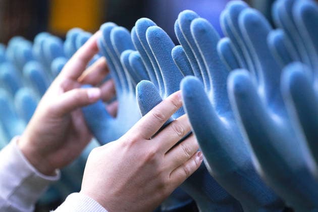 (260105) -- BEIJING, Jan. 5, 2026 -- A worker operates on a production line of protective gloves at the workshop of a company in Gaomi, east China s Shandong Province, Jan. 4, 2026. (Photo by Xinhua) XINHUA PHOTOS OF THE DAY LixHaitao 