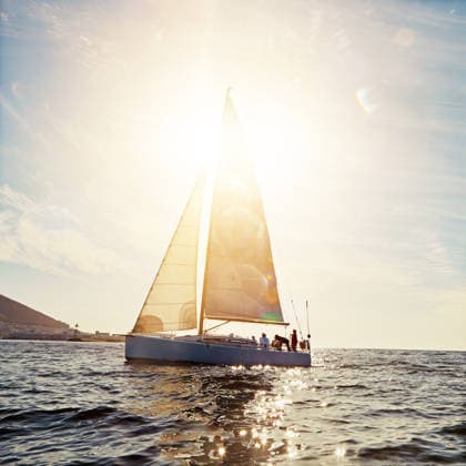 Yacht, people and sailing in summer, ocean and sky with flare, space and tourism on vacation. Group, friends and travel at sea, outdoor and luxury boat transport for sightseeing cruise on holiday. model released property released Copyright: xx