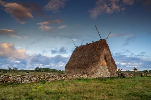 Blick auf den historischen Steinschuppen Hundslausar mit Reetdach auf der Insel Gotland bei Sonnenaufgang Burgsvik, Sweden - 12 September, 2025: view of the historic Hundslausar stone shed with thatched roof on Gotland Island at sunrise (License=RF) Copyright: xZoonar.com NandoxLardix 24417598