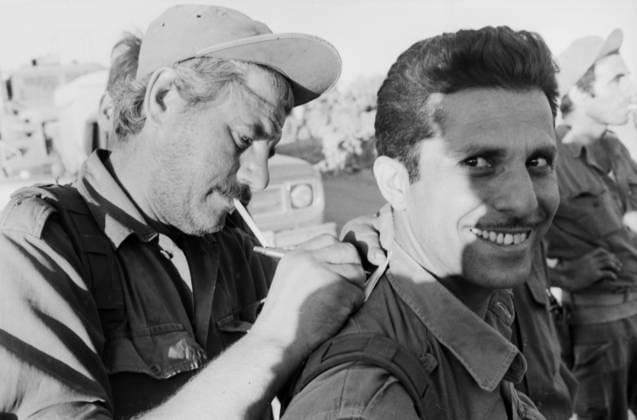 Ein israelischer Soldat schreibt mit Zigarette im Mund eine Nachricht oder Feldpostkarte auf dem Rücken eines Kameraden während einer Gefechtspause im Jom-Kippur-Krieg 1973 ab. Golan-Höhen Syrien *** a Israeli Soldier writes with Cigarette at Mouth a Message Or Feldpostkarte at the Back one Comrades during a Break in combat at Jom KIPPUR War 1973 from Golan Heights Syria Copyright: xUnitedxArchivesx xSvenxSimonxArchives SVS_94010002374