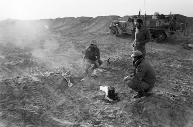 Oktober 1973, Jom-Kippur-Krieg: Israelische Soldaten kochen in einer Gefechtspause Kaffee im Sand, ein Militärfahrzeug steht im Hintergrund. Wüste Sinai Ägypten *** October 1973, Jom KIPPUR War Israeli Soldiers cook in a Break in combat Coffee at Sand, a Military vehicle is at Background Desert Sinai Egypt Copyright: xUnitedxArchivesx xSvenxSimonxArchives SVS_94010002603