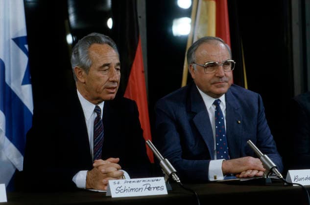 Peres Shimon und Helmut Kohl sitzen bei einer gemeinsamen Pressekonferenz vor Mikrofonen; hinter ihnen wehen Nationalflaggen. Die Tischschilder tragen Inschriften. Deutschland, 1980er Jahre. Bonn Nordrhein-Westfalen West Deutschland *** Peres Shimon and Helmut Kohl sit at a joint Press conference before Microphones behind them breeze National flags the Table signs carry Inscriptions Germany, 1980s Years Bonn North Rhine Westphalia WEST Germany Copyright: xUnitedxArchivesx xSvenxSimonxArchives SVS_94040000022