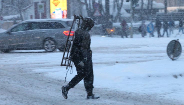 Driving snow on Thursday morning in Hamburg A man walks with a sledge on his shoulder across a street covered in snow Barmbek Hamburg