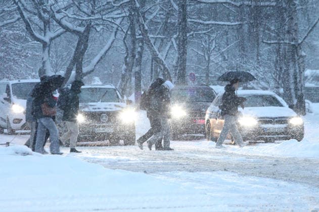 Driving snow on Thursday morning in Hamburg Passers-by walk with umbrellas across a street covered in snow Winterhude Hamburg