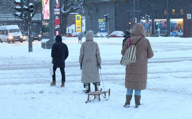 Driving snow on Thursday morning in Hamburg Passers-by standing at a pedestrian crossing The street is covered in snow Winterhude Hamburg