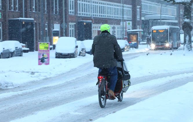 Driving snow on Thursday morning in Hamburg A man rides his cargo bike on a street covered in snow Barmbek Hamburg