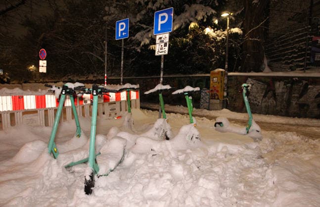 E-scooters covered in snow are parked in a parking lot reserved especially for them in Schanzenstraße Sternschanze Hamburg during storm Elli