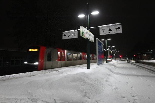 A subway train on line U3 enters the Saarlandstraße stop The platform is covered with snow during the storm Elli Barmbek Hamburg