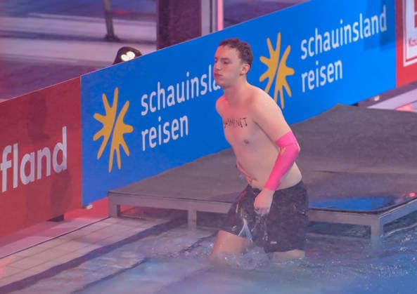 10 01 2026, xlakx, Entertainment, TV Total Turmspringen v l Let™s Hugo Streamer holds the hand on the stomach at the 15th edition of TV Total Turmspringen in Berlin from the diving boards of the swimming and diving hall in the Europasportpark SSE a spectacular highlight of the show on ProSieben Berlin Daniel Lakomski
