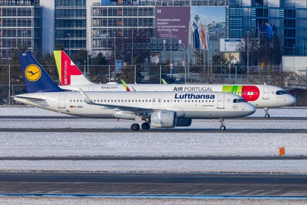 Flughafen München im Schneebetrieb während Kältewelle in Bayern, Oberding, 11.01.2026 Ein Airbus A320neo der Lufthansa mit dem Kennzeichen D-AINH rollt bei winterlichem Wetter am Flughafen München an einem Flugzeug von TAP Air Portugal vorbei. Im Hintergrund ist das Terminal 2 sichtbar. Zwischen Lufthansa und TAP laufen derzeit Diskussionen über eine mögliche Beteiligung oder Übernahme. Oberding Flughafen München Bayern Deutschland *** Munich Airport operating in the snow during a cold spell in Bavaria, Oberding, 11 01 2026 A Lufthansa Airbus A320neo with the registration D AINH taxis past a TAP Air Portugal aircraft in wintry weather at Munich Airport Terminal 2 is visible in the background Discussions are currently underway betwee 20260111-286A5894-M4000
